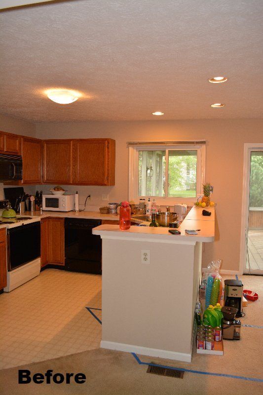 The same kitchen before work, with a closed off peninsula and a laminate countertop